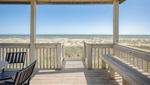 Une terrasse en bois avec vue sur l’océan.