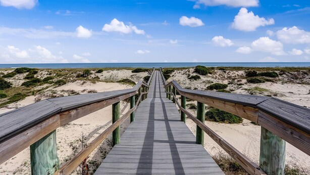 A wooden boardwalk leading to a beach with sandy dunes and sparse vegetation. - RENOVATED Ocean Front 2-story Condo  - Access to Amelia Island Golf & Beach Club (Fernandina Beach)