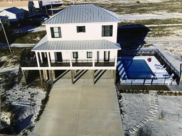 A two-story house with a balcony and a pool area.
