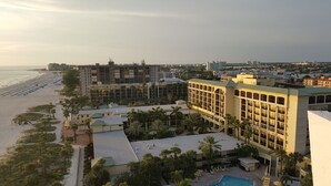 Um hotel à beira-mar com vários edifícios, piscina e área de praia.