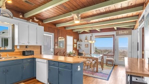 Cocina con armarios azules, lavavajillas e isla de madera.
