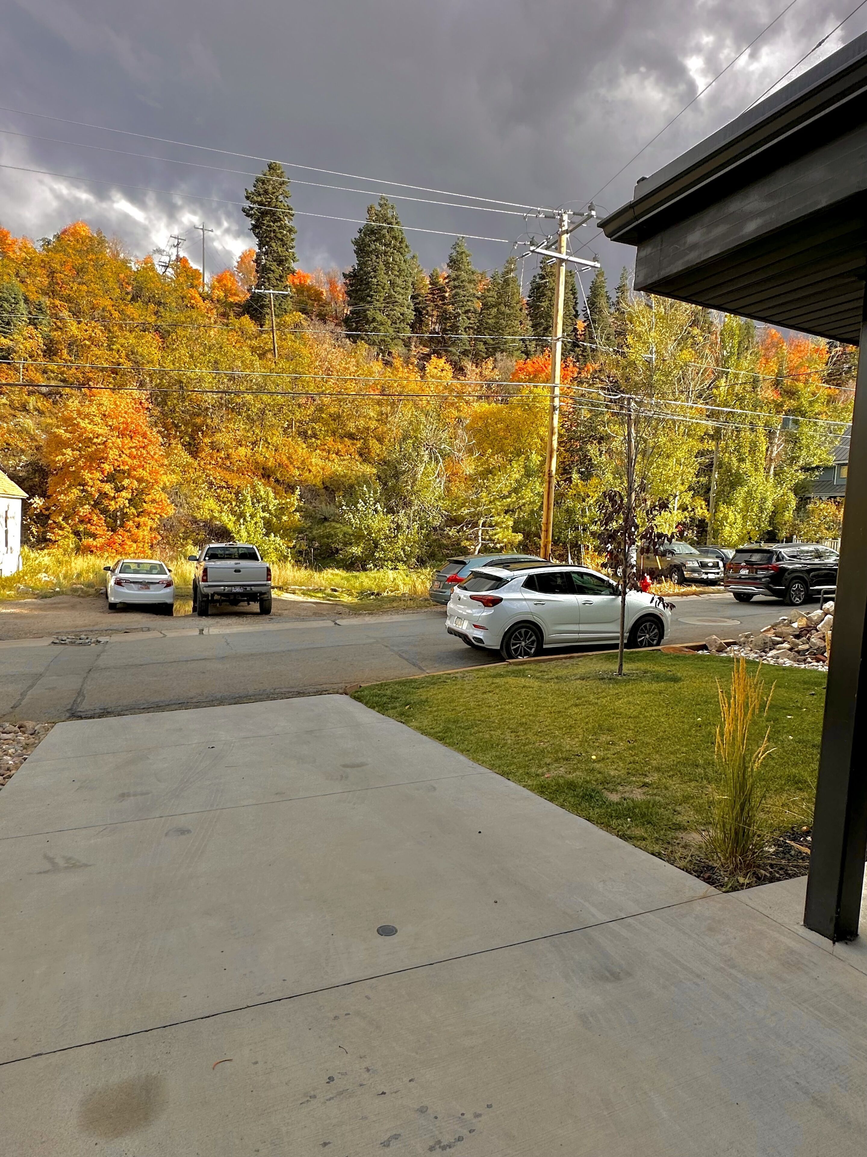 A residential driveway with parked cars and a house.