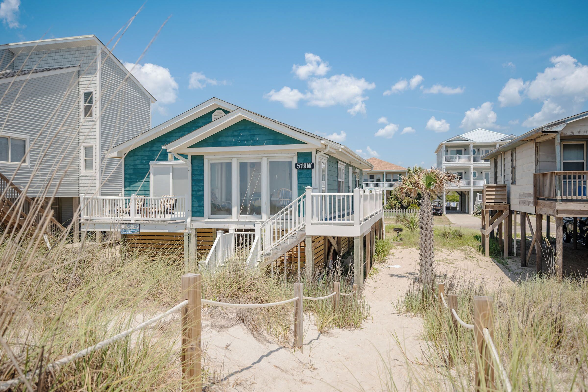 A beachfront property with a house featuring a deck and a covered walkway.