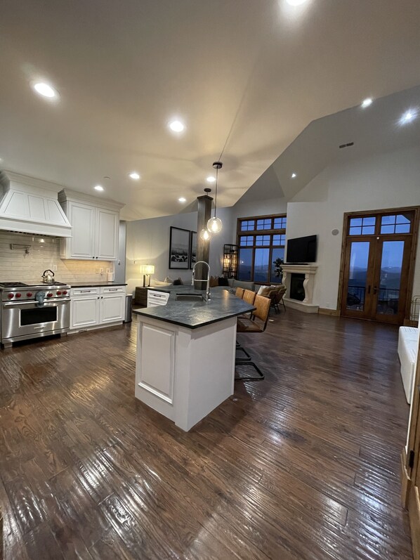 Enjoy meals and relaxation in this kitchen with a central island, stove, oven, and seating area.