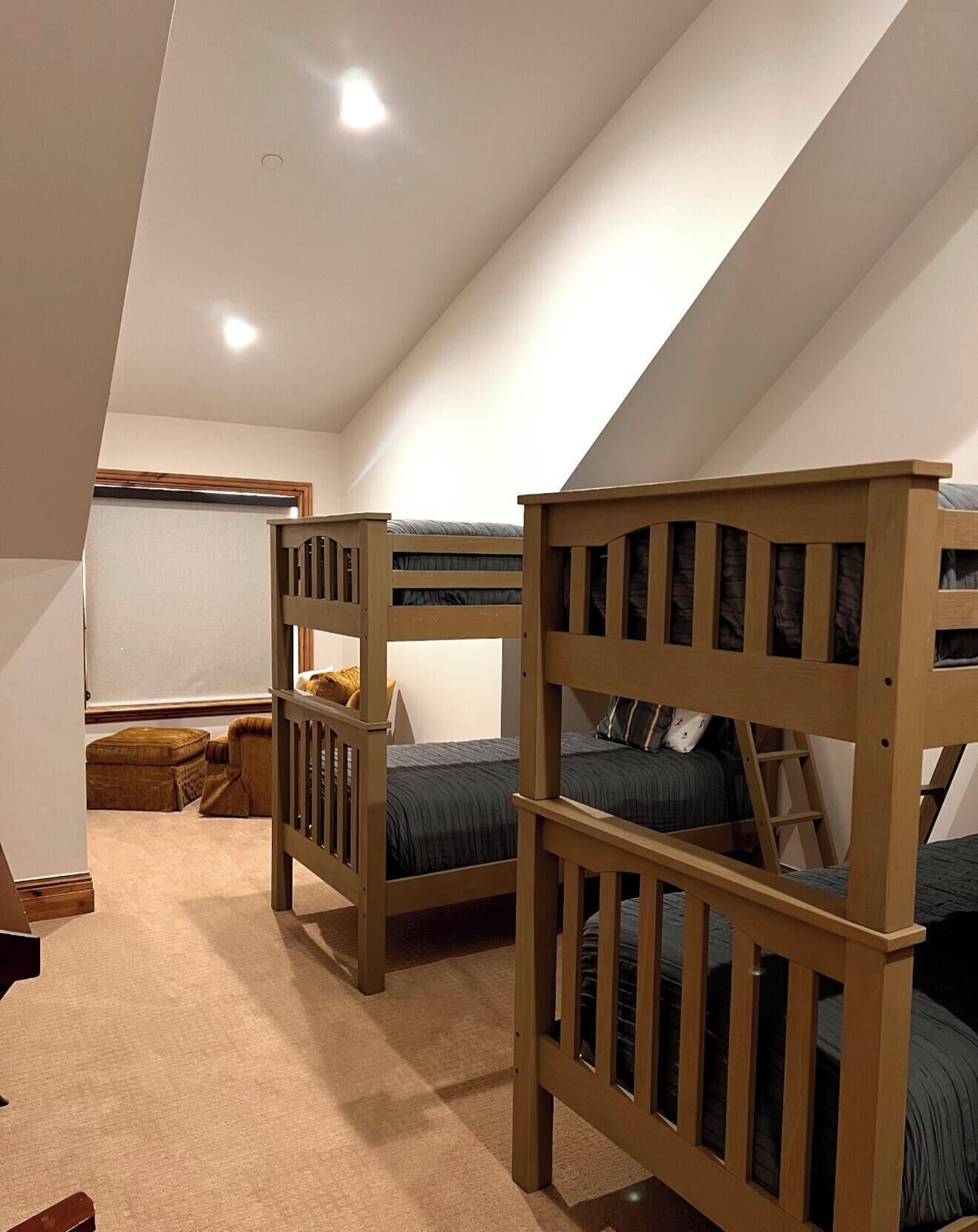 A bedroom with two bunk beds, a window, and a carpeted floor.