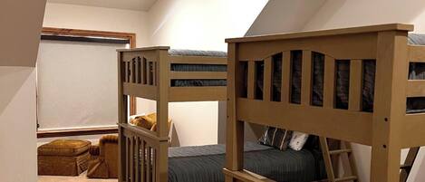 A bedroom with two bunk beds, a window, and a carpeted floor.