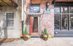 A building with a brick facade, a numbered door, and a sign indicating a southern market.