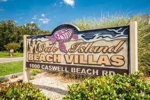 Letrero de Oak Island Beach Villas con un gráfico de tortuga.
