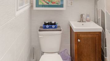 Une salle de bain avec des toilettes, un lavabo et un meuble de rangement.