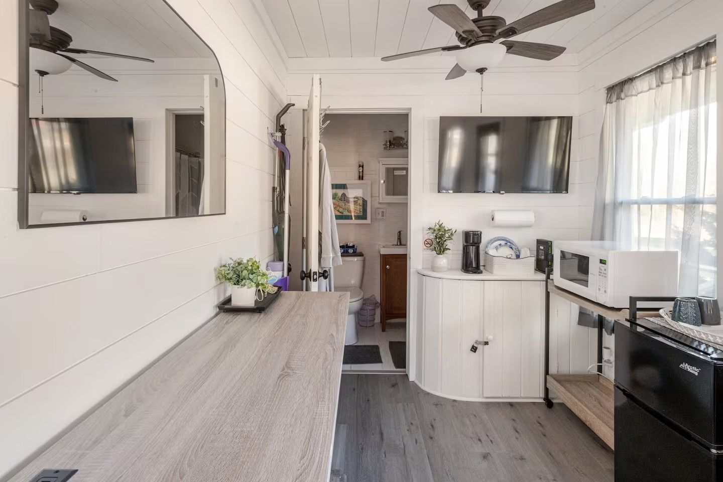 A compact kitchen with a microwave, a coffee maker, and a sink.