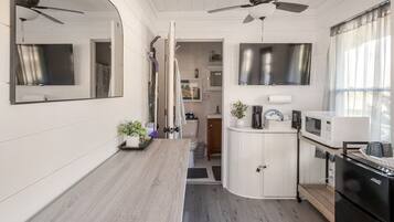 A compact kitchen with a microwave, a coffee maker, and a sink.