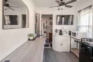 A compact kitchen with a microwave, a coffee maker, and a sink.