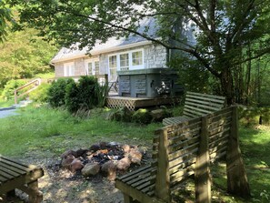 A stone building with a fire pit and wooden benches. - Peaceful Hocking Hills Vacation Retreat (Rockbridge)