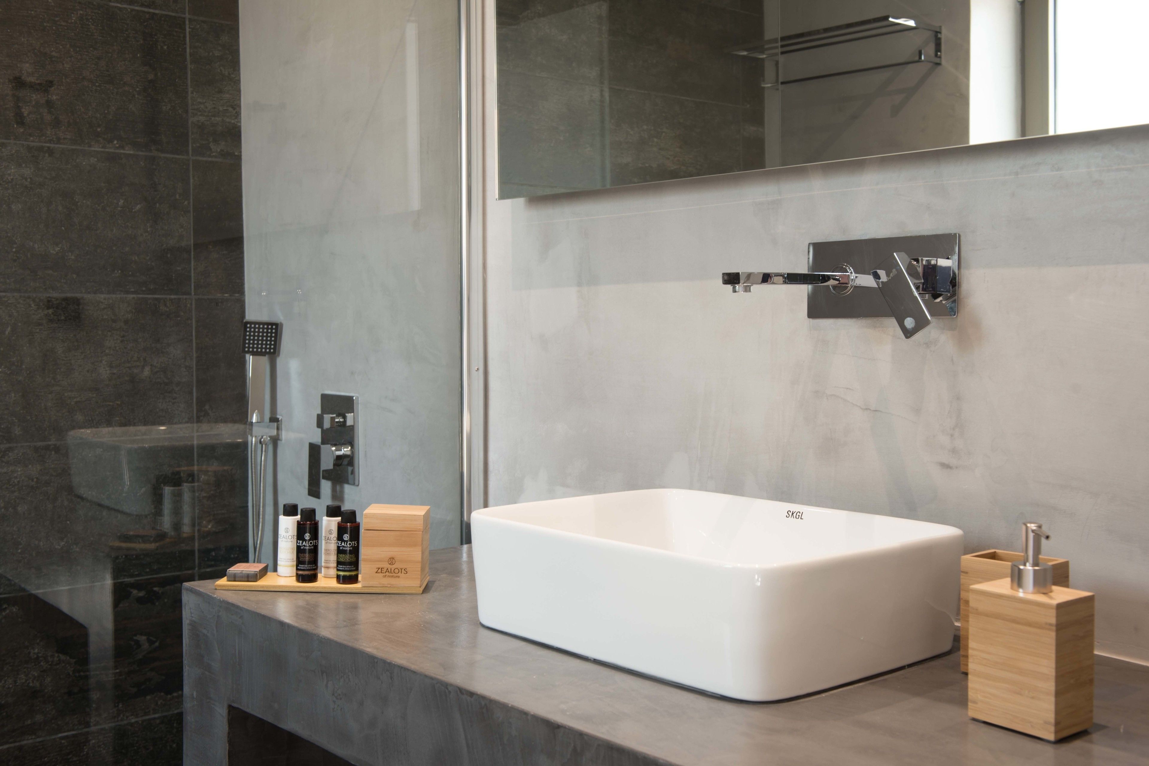A modern bathroom with a large white bathtub, a glass shower enclosure, and a minimalist design.
