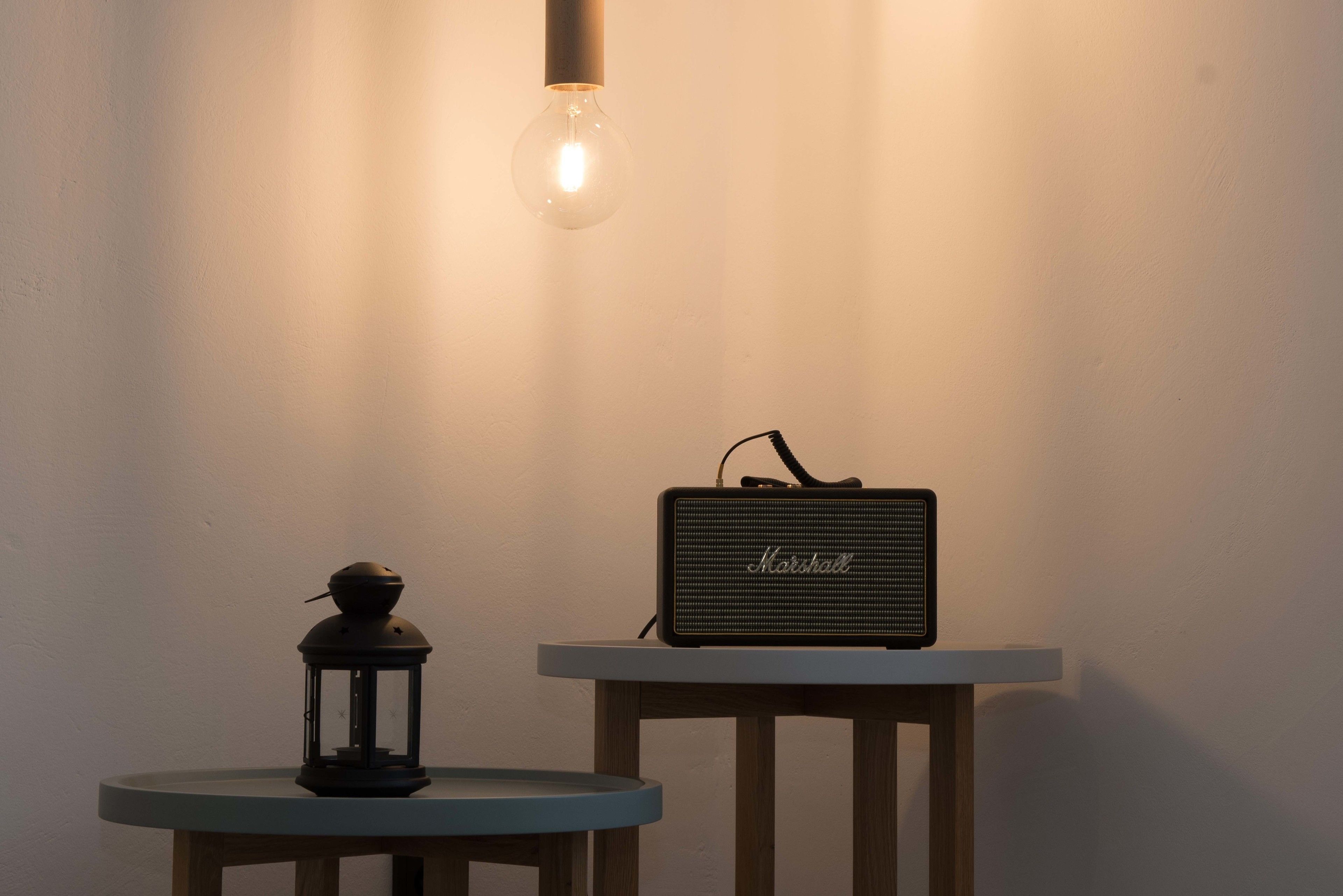 A table with a lamp and a speaker.
