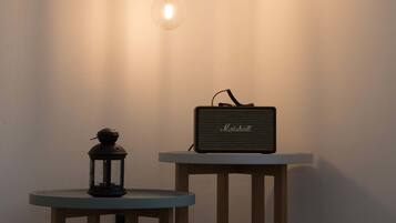 A table with a lamp and a speaker.