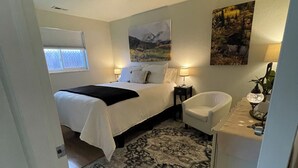 A bedroom with a bed, bedside lamps, a rug, a chair, and artwork on the walls. - Fantastic Denver Location! 5 mins from every major highway! Mountain & Lake View (Denver)