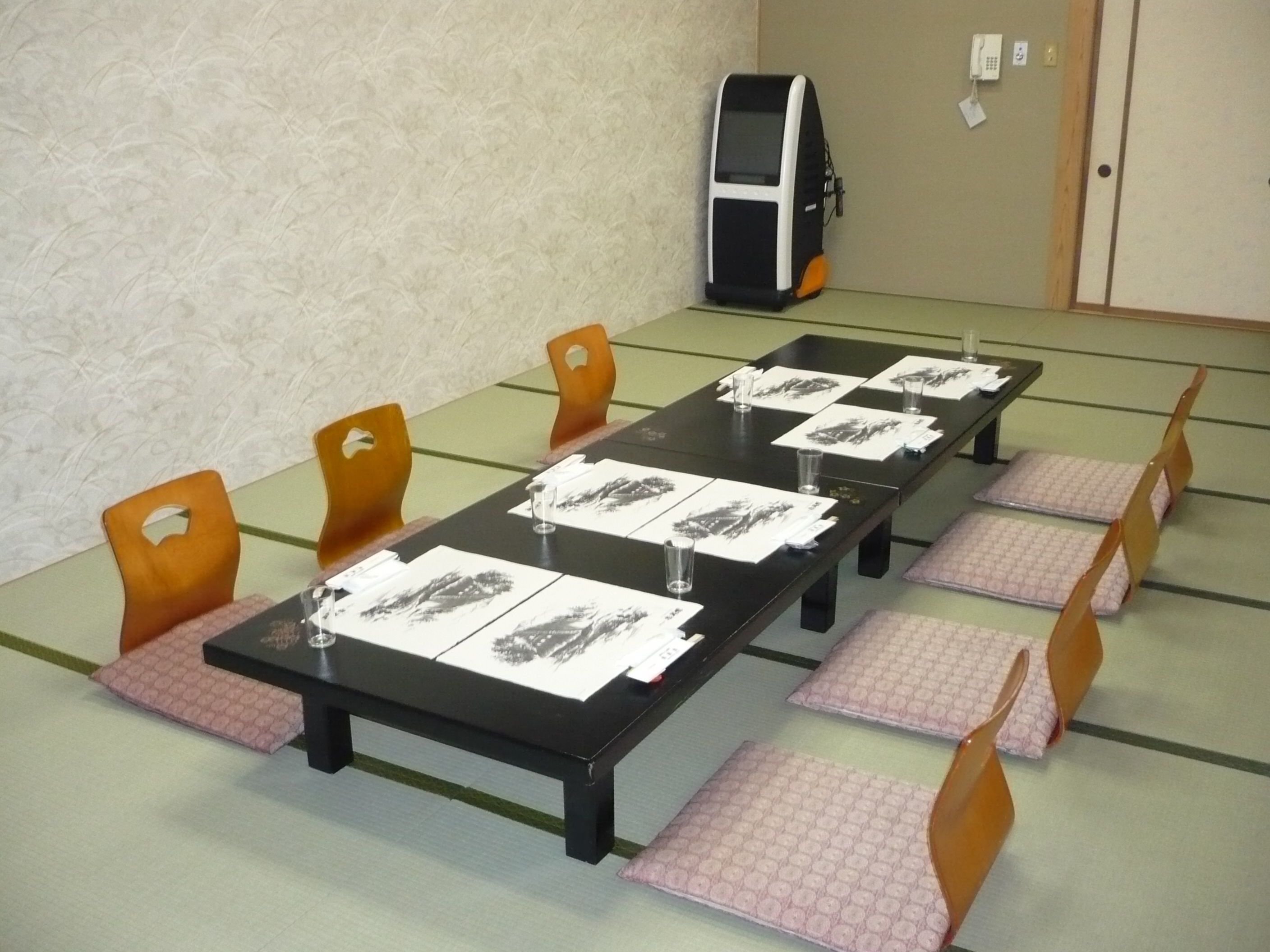 A conference room with a long table, chairs, and a telephone.