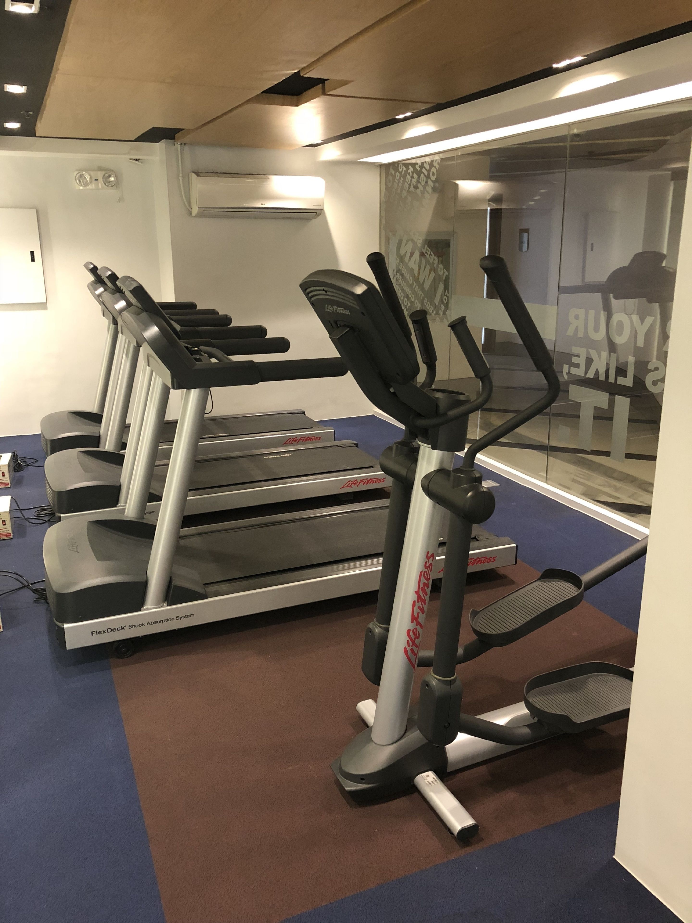 A gym with treadmills, a stationary bike, and a weight bench.