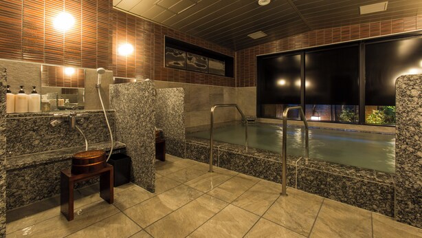 Une salle de bain moderne avec un lavabo en marbre, une douche et un espace piscine.