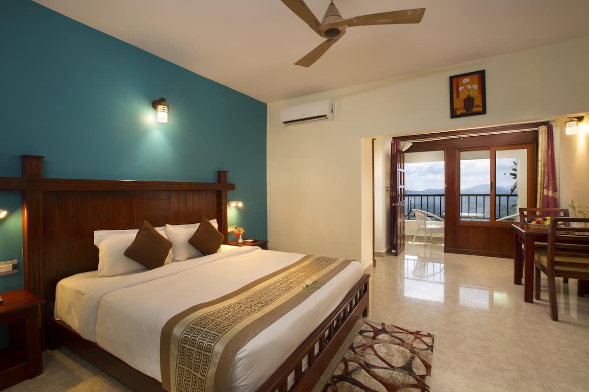 A hotel room with a large bed, wooden headboard, and a view of the outdoors through a sliding door.