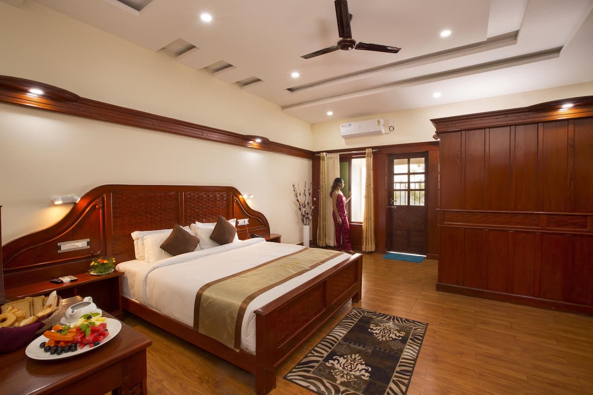 A spacious bedroom with a large bed, wooden headboard, and a ceiling fan.