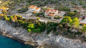 Une propriété située sur la côte, comprenant plusieurs maisons, un terrain rocheux et offrant une vue dégagée sur la mer.