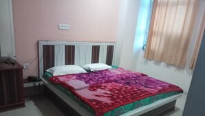 Une chambre à coucher avec un lit, une table de chevet et une fenêtre avec des rideaux.