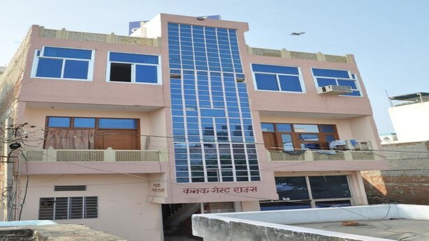 Un immeuble à plusieurs étages doté d’une façade centrale en verre, de balcons à chaque étage et d’une enseigne en langue locale.