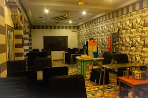 A room with striped walls, a ceiling fan, a table with chairs, and a patterned wall.