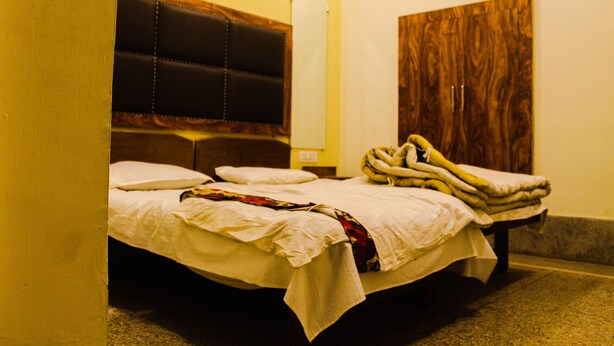 Una habitación de hotel con cama, cabecero de madera y armario.