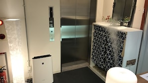A modern elevator with a digital display, a fire extinguisher, and a small table with a lamp. - bnb+ Ninja Otsuka - Hostel (Tokyo)
