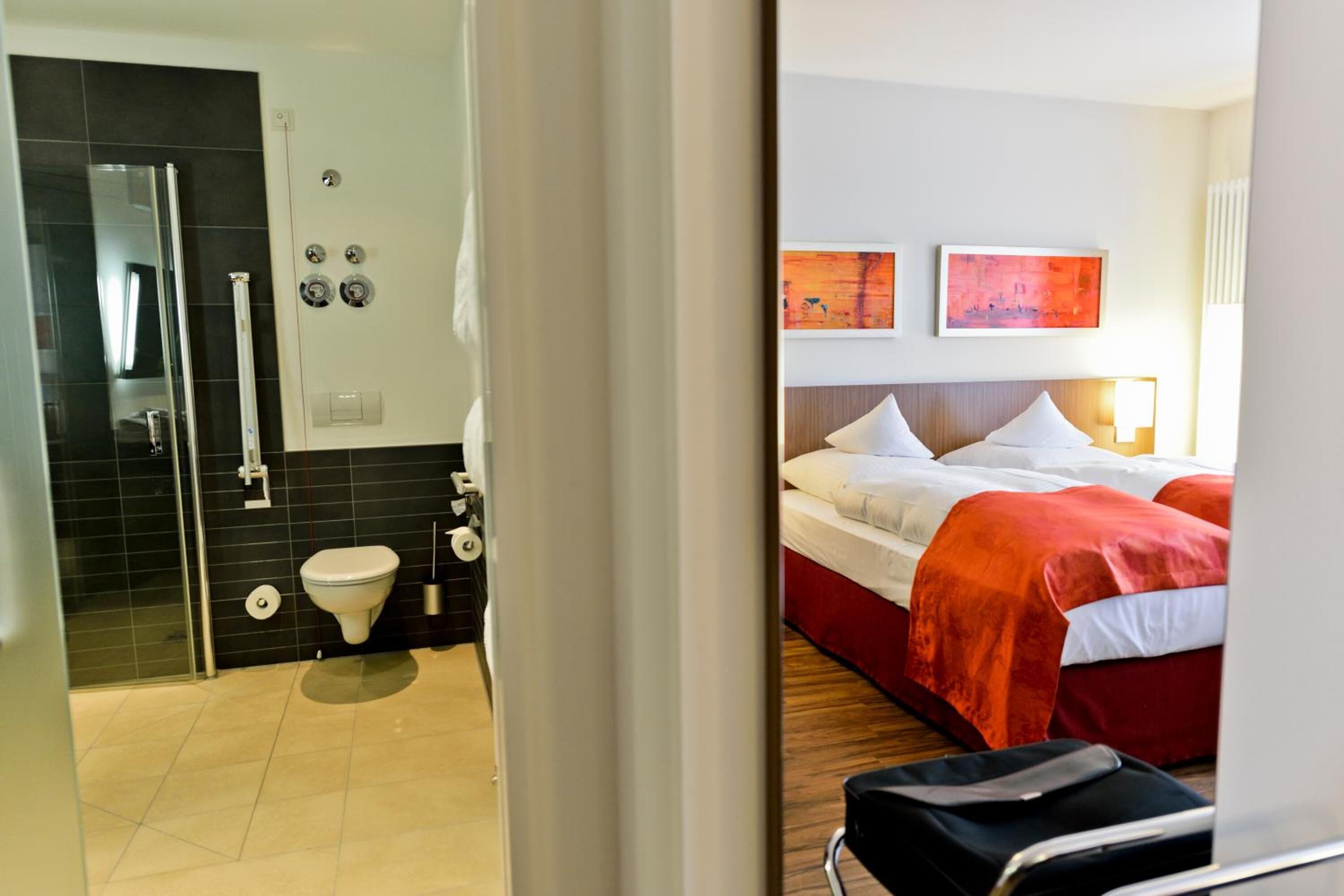 Une chambre d’hôtel avec douche, toilettes et lit.