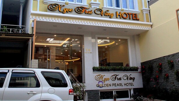 A hotel with a yellow facade, multiple windows, and a sign reading "Ngoc Trai Vang Hotel." - Ngoc Trai Vang Hotel (Xuan Huong - Da Lat)