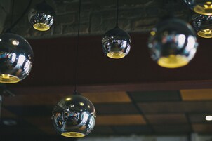 Varias lámparas colgantes esféricas con superficies reflectantes suspendidas del techo.