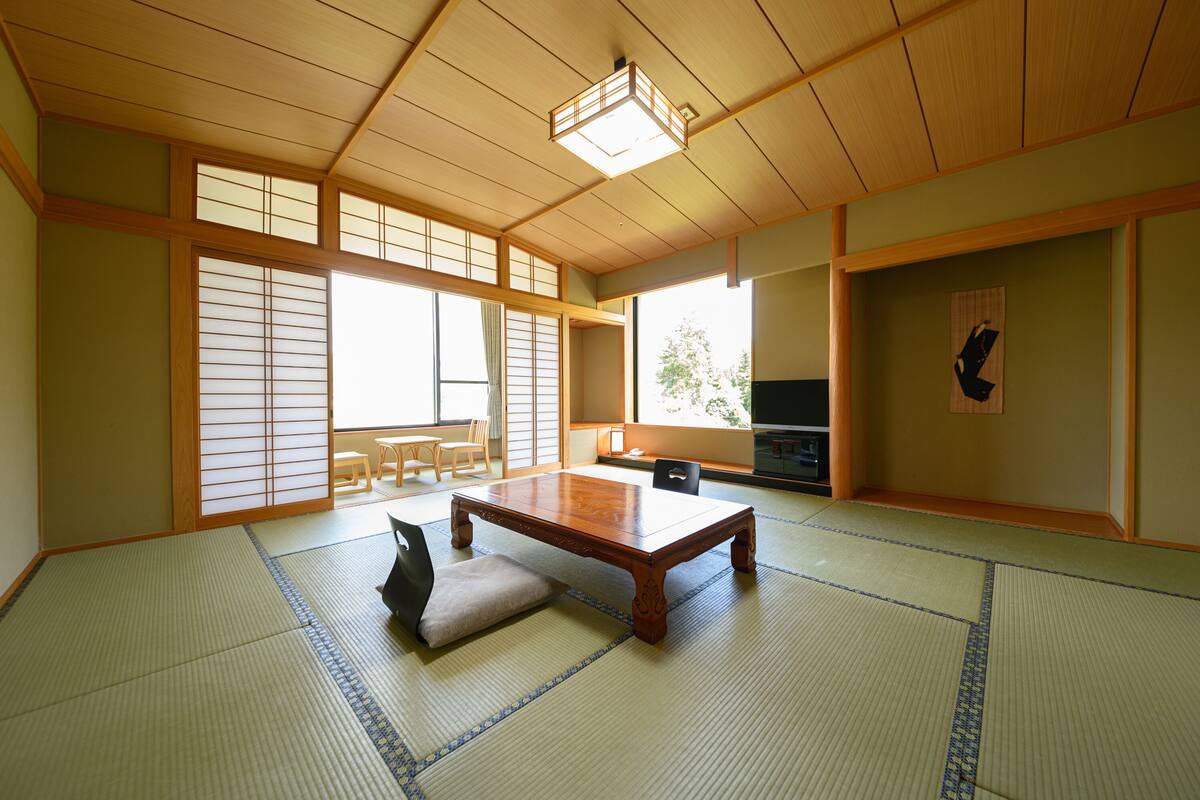 A traditional Japanese room with tatami flooring, a low wooden table, and sliding doors.