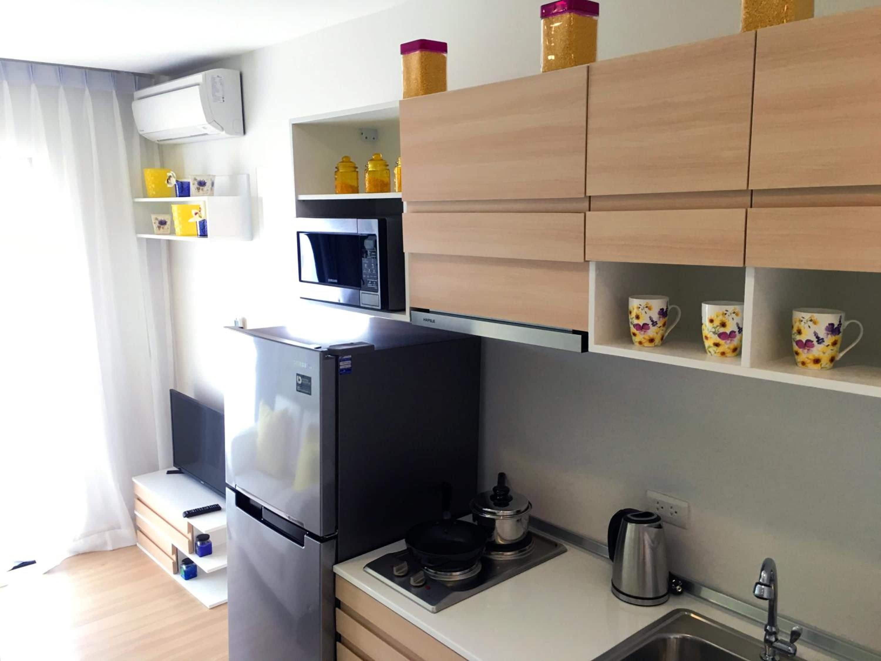 Cocina compacta con refrigerador, microondas y estufa.
