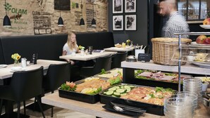 A buffet setup with various food items and a wall with informational posters. - Hotel Hansa (Herford)