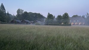 A field with a row of houses in the background. - Hotel Forsthaus Luchsenburg (Ohorn)