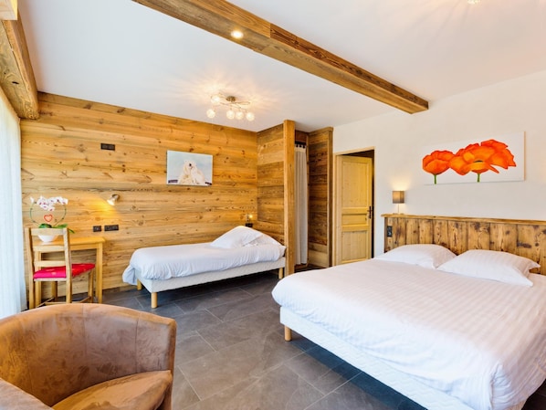 Ein Zimmer mit zwei Einzelbetten, einer Holzwand, einem Gemälde von Eisbären und einem Blumenbild.