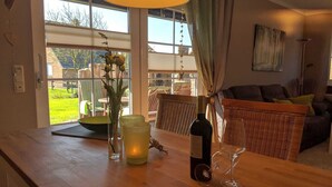 Ein Holztisch mit einer Weinflasche, einem Glas und einer Kerze.