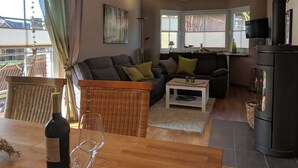 Ein gemütliches Wohnzimmer mit einer Couch, einem Couchtisch und einem Essbereich mit Tisch und Stühlen.