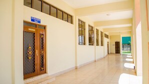 A corridor with a sign for 'Kilimanjaro Hall' leading to a door with a decorative pattern. - The Starbucks Hotel (Eldoret)