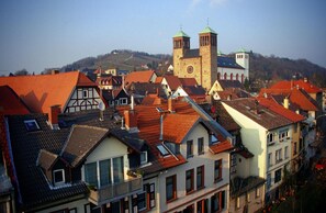 A town with traditional European architecture, including a prominent church with two towers and a hillside in the background. - Bacchus Hotel (Bensheim)