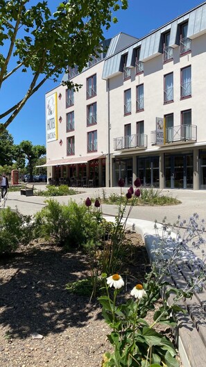 A hotel with a sign reading "HOTEL BACCHUS" and a visible outdoor seating area with tables and chairs. - Bacchus Hotel (Bensheim)
