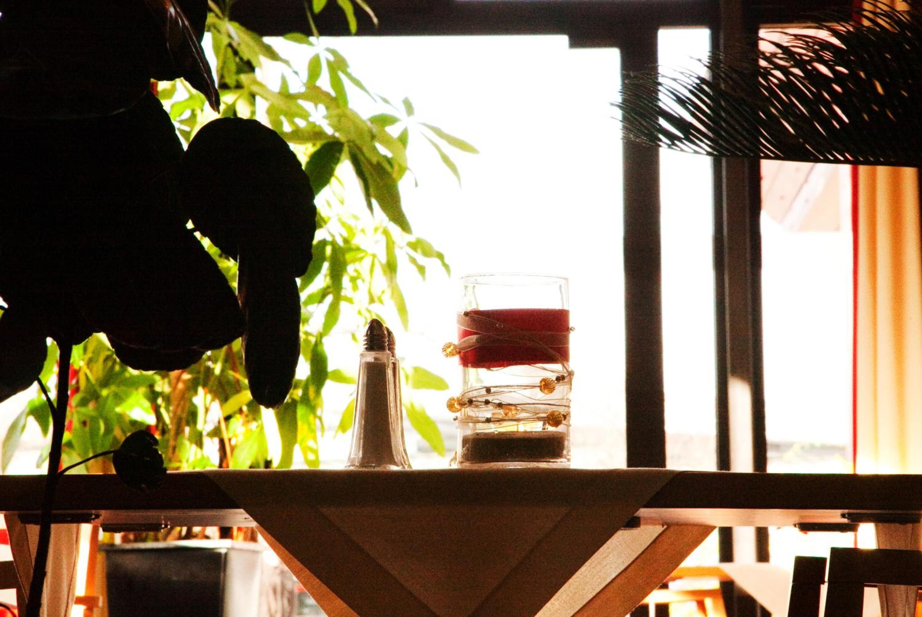 Una mesa con un vaso, una vela y un salero.