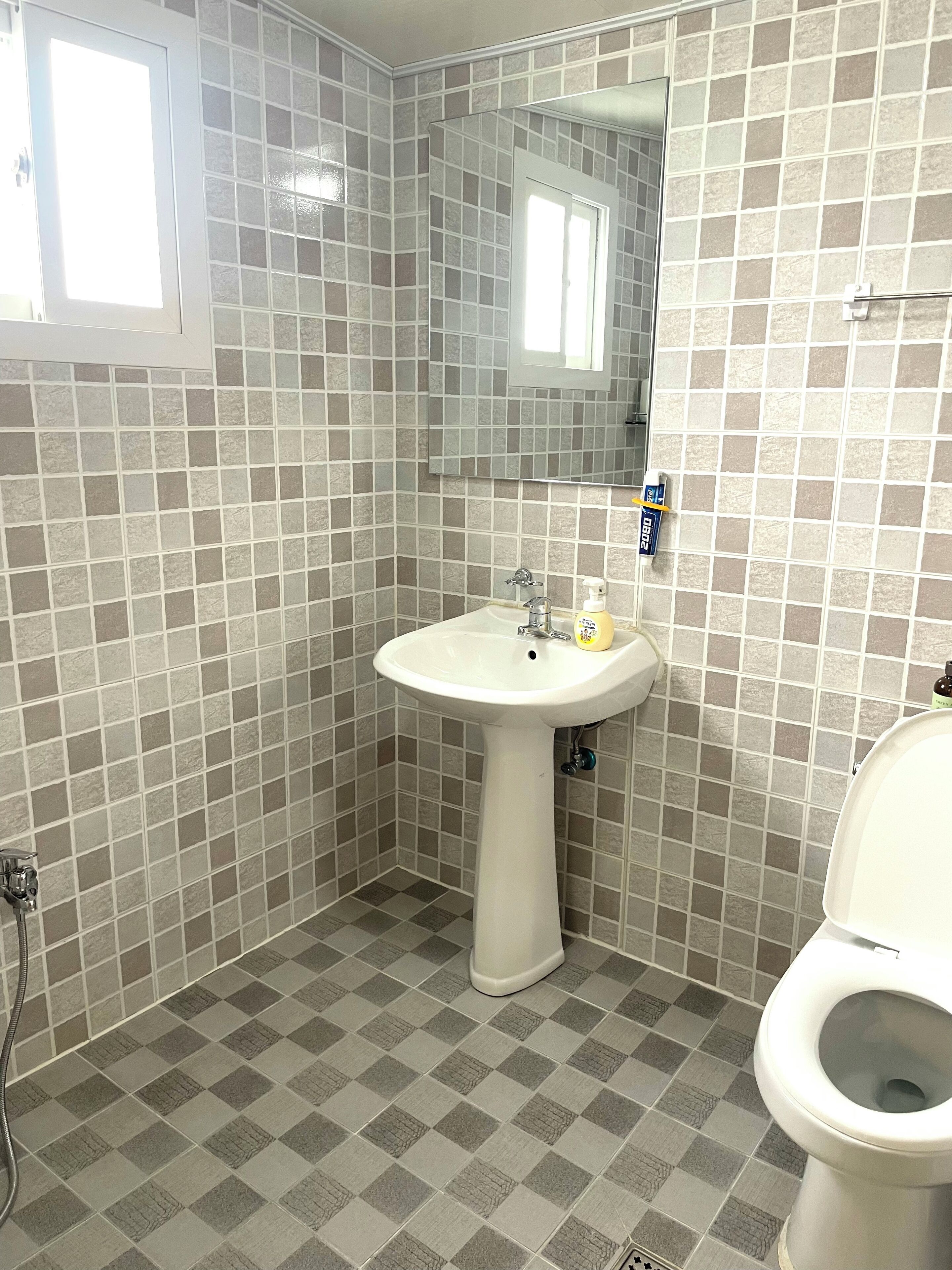 Un baño con un lavabo blanco, un espejo y un inodoro.