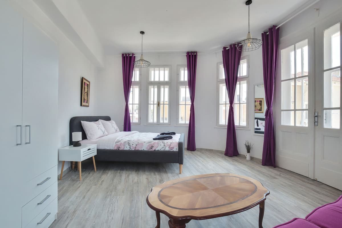 A bedroom with a bed, bedside table, and a small table.