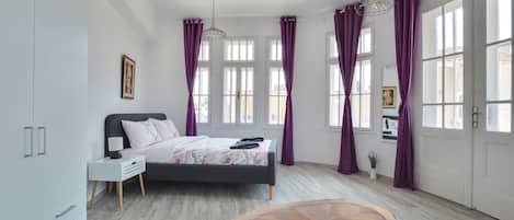 Un dormitorio con cama, mesita de noche y una pequeña mesa.