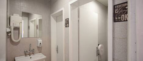 A bathroom with a sink, mirror, and two doors.